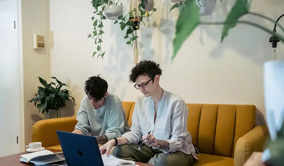 Duas pessoas conferindo informações de funcionários no notebook